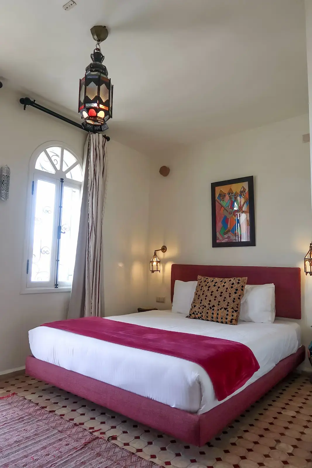 The bed in the Medina Junior Suite with a view of the outside from the window.