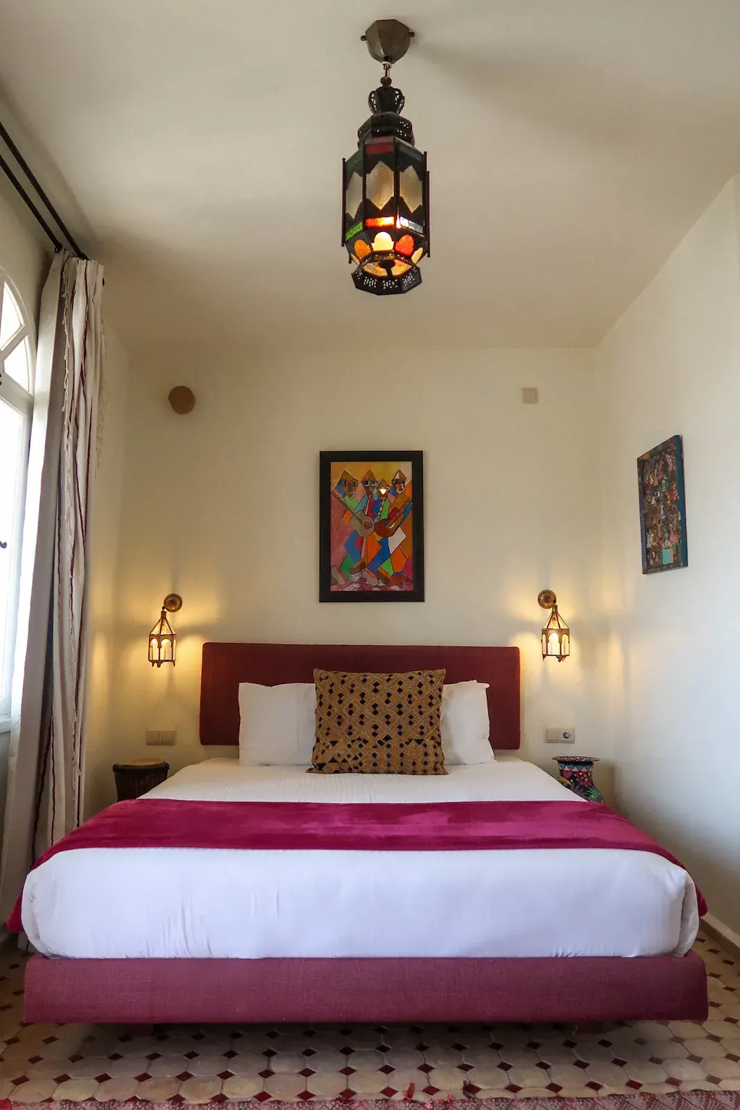 A full view of the bedroom in the Medina Junior Suite at Kasbah Rose, showing the bed and unique African decor.