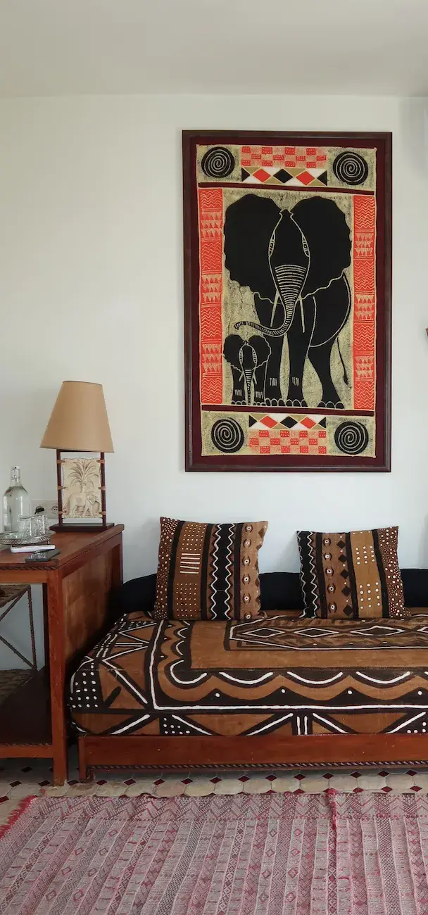 Das Sofa und die lebendige afrikanische Kunst an der Wand in der Medina Junior-Suite.