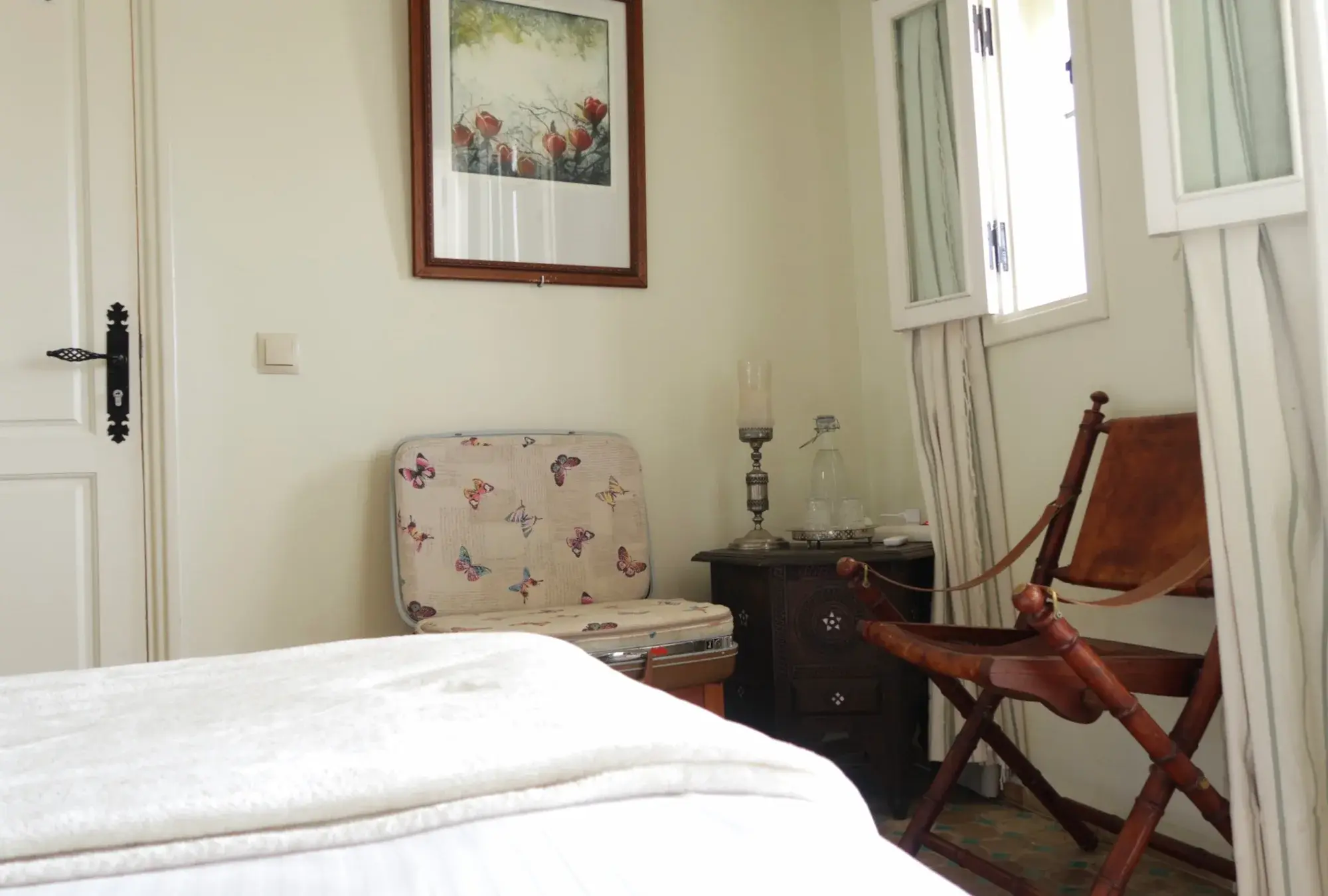 The unique suitcase repurposed into a chair and a wooden folding chair in the Senior Suite.